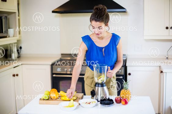 Beautiful young woman preparing juice