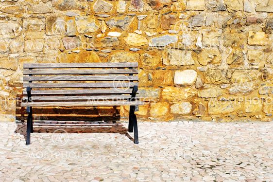Wood bench against a brick wall