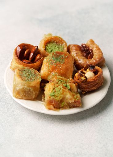 Assorted traditional sweets on a white plate showcasing...