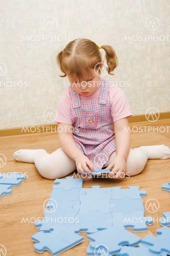 little girl collects puzzles in a room