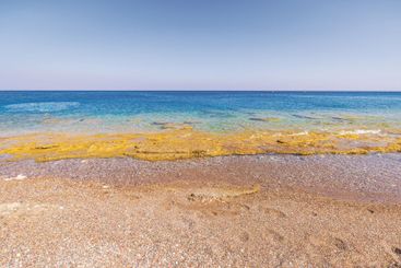 Clear turquoise water of Aegean Sea washing over rocky 