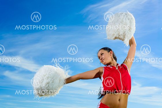 Ung cheerleader i röd dräkt med pampon