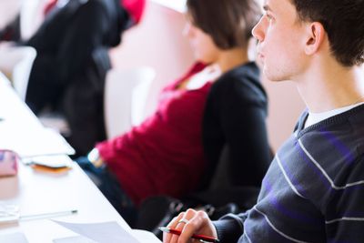 young, handsome male college student sitting in a...