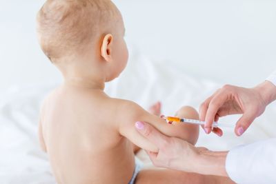 Cropped shot of medical worker making injection for cute...