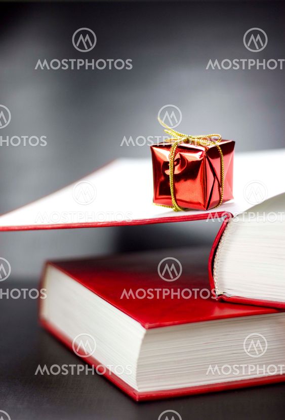 A present lying on two books on a black background