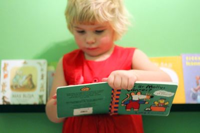 Liten flicka bläddrar i barnbok 2