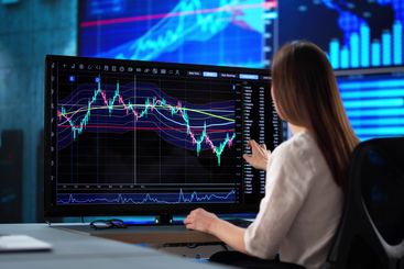 Professional woman analyzing stock market data on...