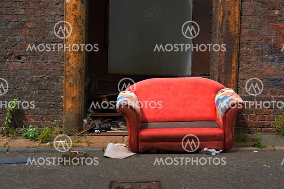 Old abandoned couch in an industrial alley way