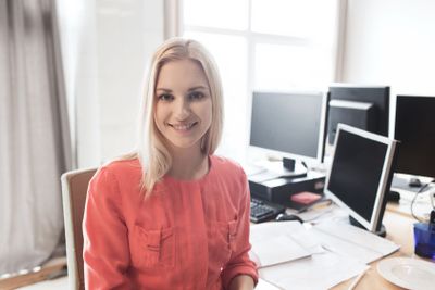happy creative female office worker with computers