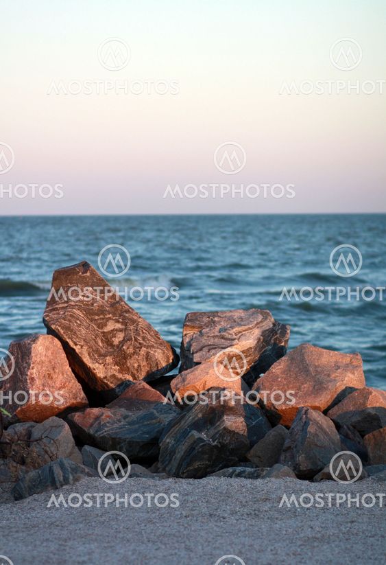 Stones on the beach by the sea at sunset