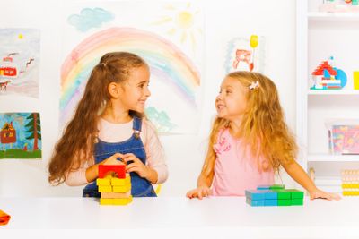 Two beautiful girls stacking blocks