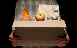 Unrecognizable man holding donation carton box with...