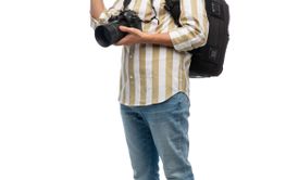 smiling male photographer with camera waving hand