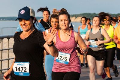 Women running a race on a boardwalk at the beach