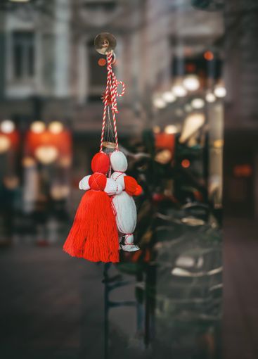 Martenitsa dolls hanging on glass window as a...