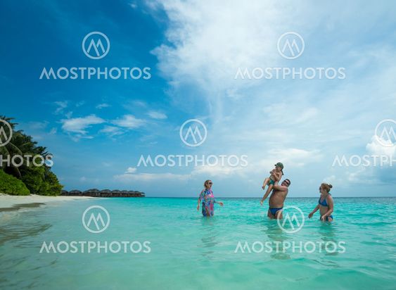 Family swims against the beautiful tropical island