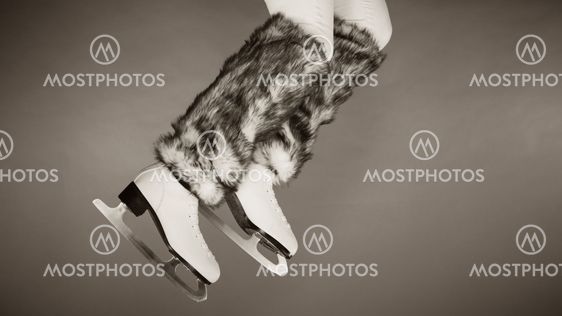 Woman legs wearing ice skates fur socks, skating