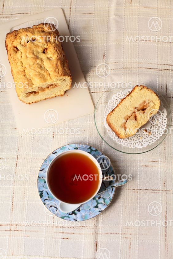 Teacup with slice of a delicious cake on a table