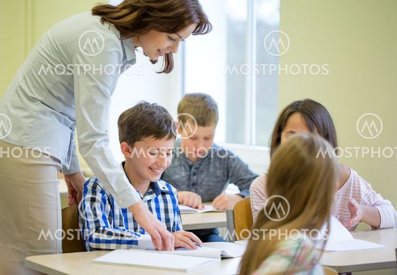 group of school kids writing test in classroom