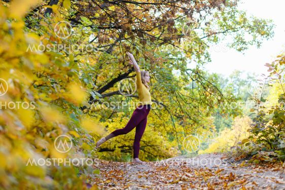 Sportive woman exercise in autumn forest path
