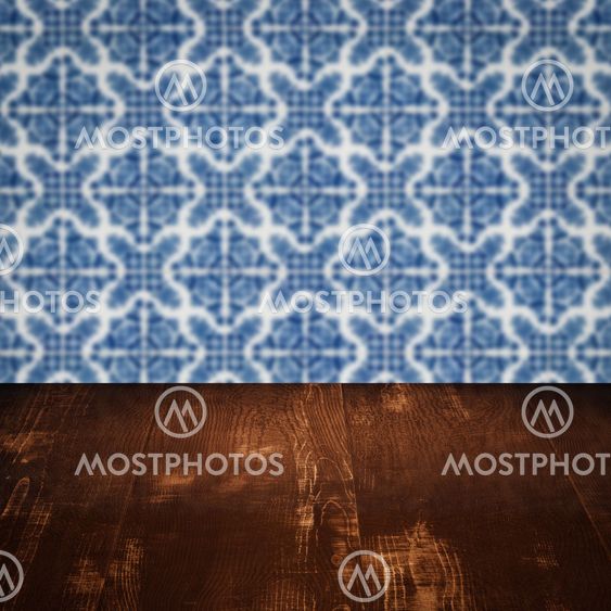 Wood table top and blur vintage ceramic tile pattern wall