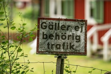 weathered swedish traffic sign on wooden post in rural...