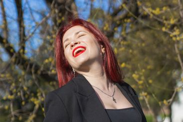 Woman with flowers surrounded by blossoming trees ....