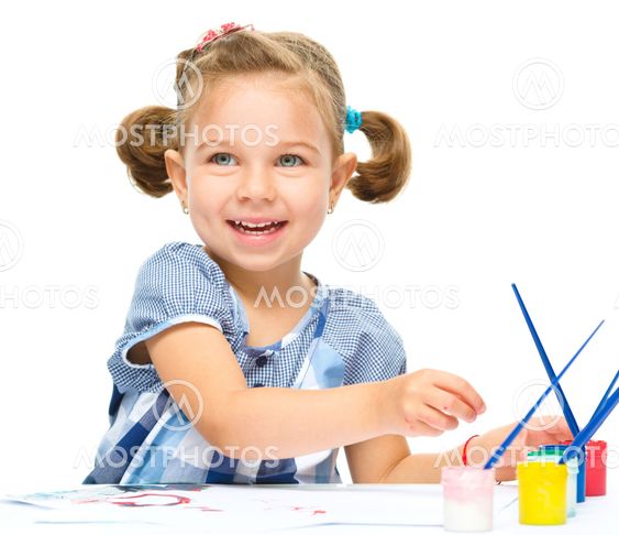 Little girl is painting with gouache