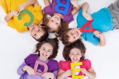 Happy school kids with colorful alphabet letters