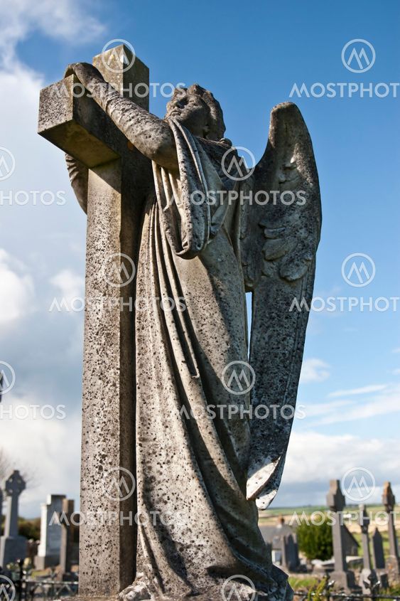 Angel statue embracing a cross and celtic graveyard
