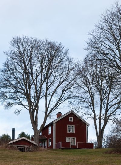 Old red wooden farmhouse in Sweden in autumn