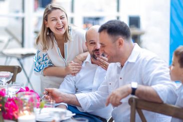 A festive banquet outdoors. A young woman and men are...