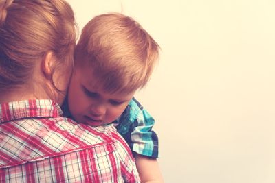 Sad unhappy child hugging his mother