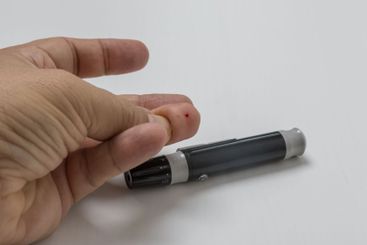 Finger with a drop of blood for measuring blood sugar level