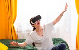 Portrait of woman sitting cross-legged on bed fully...