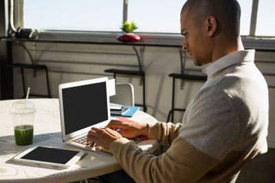 Concentrated man using laptop at office