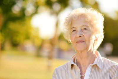 Outdoors portrait of beautiful smiling senior woman with...