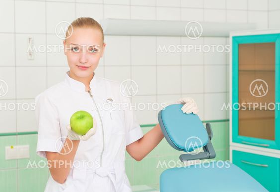 female dentists shows green apple