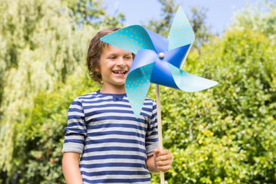 Cute boy smiling and holding a windmill