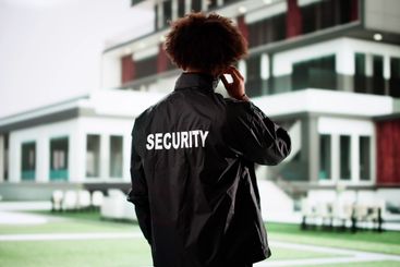 Male security guard protects house in black jacket