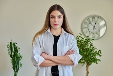 Confident young woman with crossed arms in home interior