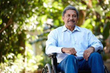 Senior man, wheelchair and smile in garden, portrait and...