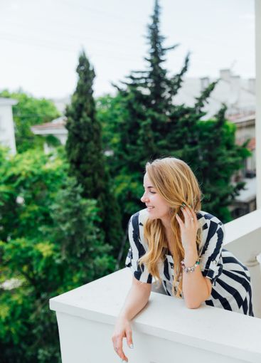 Beautiful fashionable woman in summer striped dress smiling