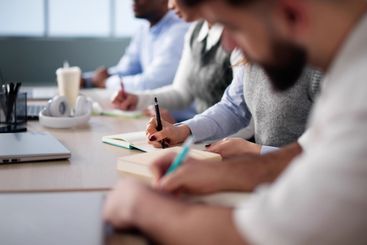 Studying In Classroom At Campus. Students Writing