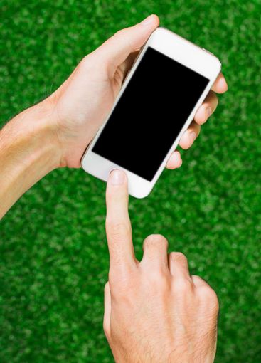Person using smartphone on green grass during daylight...