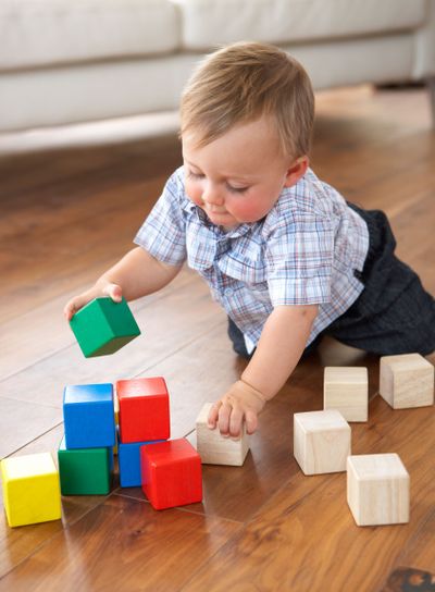 Young Boy Playing With Coloured Blocks At Home