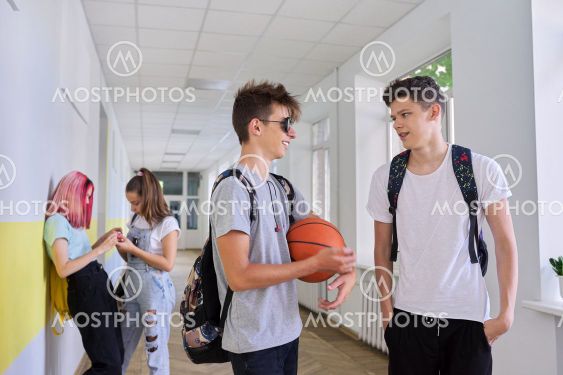 Group of teenage students talking standing outside...