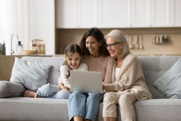 Friendly family granny mother little girl using notebook...