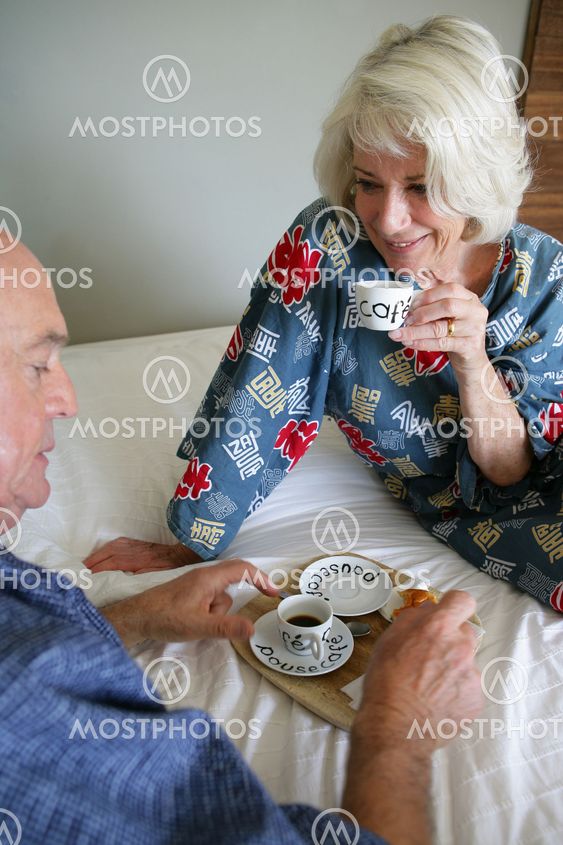 Äldre par med frukost i sängen