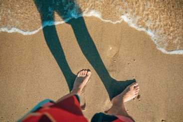 Barefoot caucasian male on sand of Aegean sea shore in...